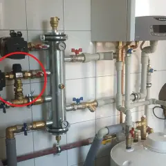 Czerwone kółko zaznacza zawór termostatyczny, kluczowy element systemu grzewczego, który reguluje temperaturę.