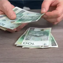 Ręce liczą banknoty 100 zł. Może to być wypłata, oszczędności, albo pieniądze na dodatek węglowy.