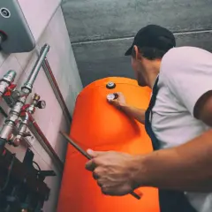 Technik sprawdza temperaturę bojlera, przygotowując się do rozliczenia za ogrzewanie.