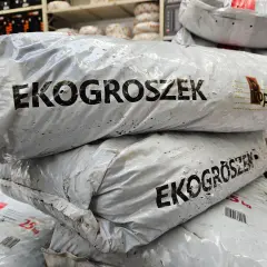 Stos worków z napisem "EKOGROSZEK z polskich kopalni". W tle regały z produktami.