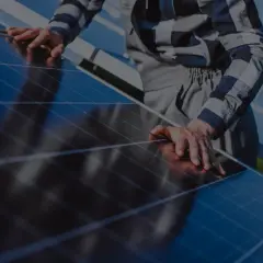 Instalator sprawdza panele fotowoltaiczne, kluczowe dla zrozumienia, jak obliczyć moc paneli fotowoltaicznych.
