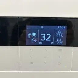 Wyświetlacz pompy ciepła Panasonic: 32°C, 44°C (woda), -1°C (zewnętrzna). Grzałka włączona.