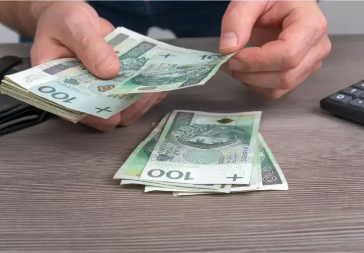 Ręce liczą banknoty 100 zł. Może to być wypłata, oszczędności, albo pieniądze na dodatek węglowy.