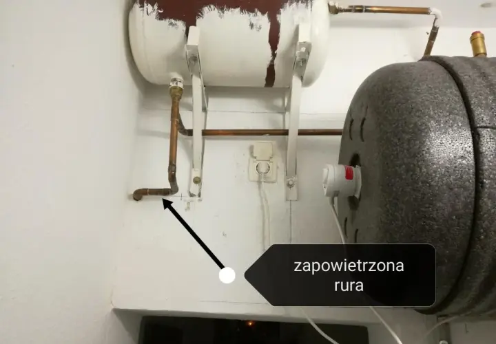 Instrukcja jak odpowietrzyć bojler przy piecu. Strzałka wskazuje zapowietrzoną rurę przy bojlerze.