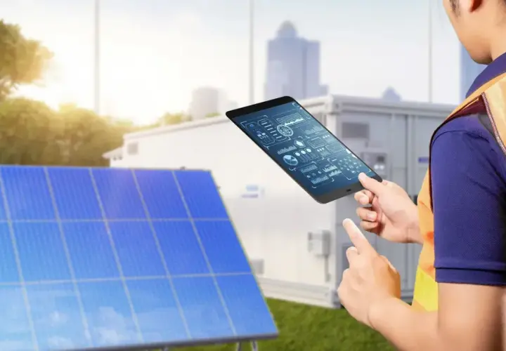 Technik z tabletem analizuje dane z paneli słonecznych. Pokazuje, jak połączyć falownik z wifi, by monitorować energię.