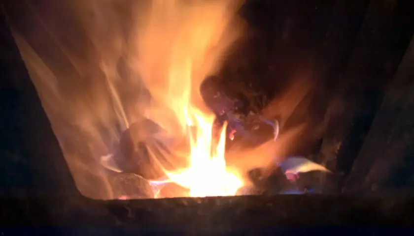 Jasne płomienie tańczą wokół żarzących się brykietów ze słomy, tworząc ciepłą, przytulną atmosferę.
